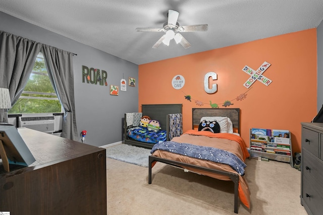 bedroom featuring ceiling fan, light colored carpet, cooling unit, and a textured ceiling