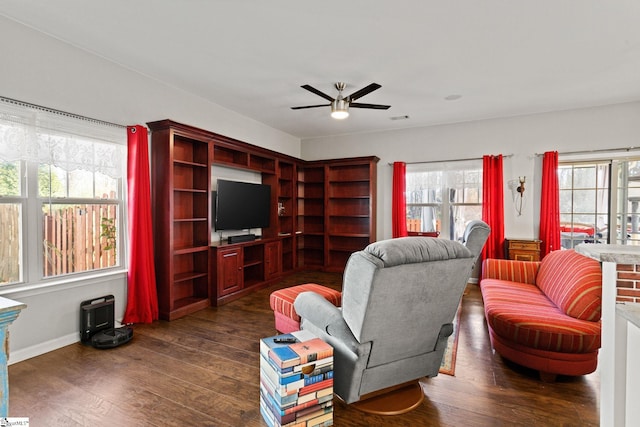 living room featuring ceiling fan, dark wood-type flooring, and a fireplace