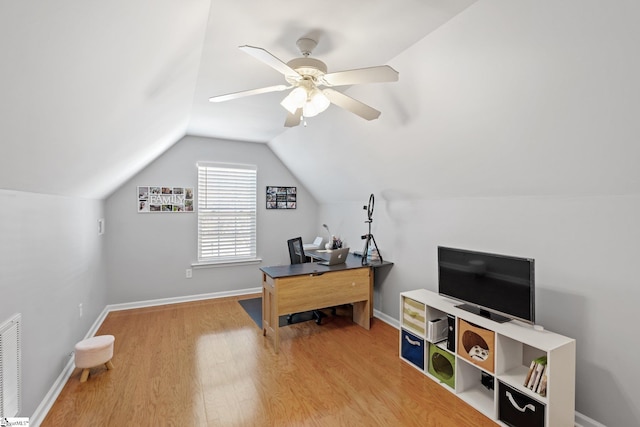 home office featuring hardwood / wood-style floors, ceiling fan, and vaulted ceiling