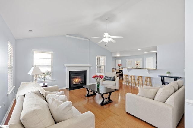 living room featuring lofted ceiling, ceiling fan, and light hardwood / wood-style floors