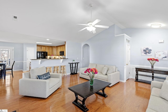 living room featuring ceiling fan, light hardwood / wood-style floors, and high vaulted ceiling