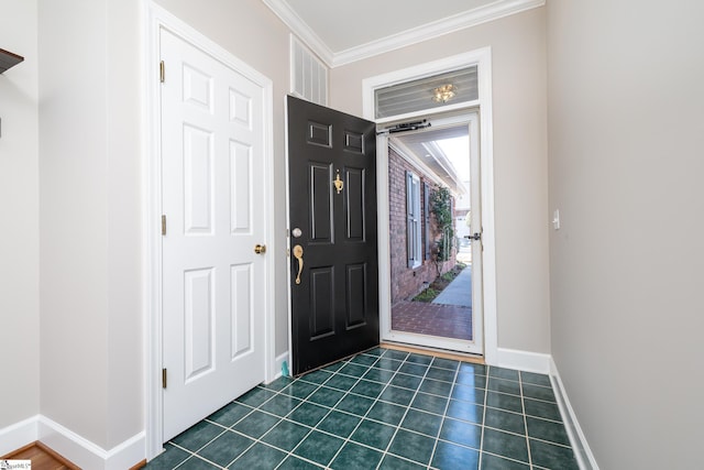 foyer entrance featuring dark tile patterned flooring and crown molding