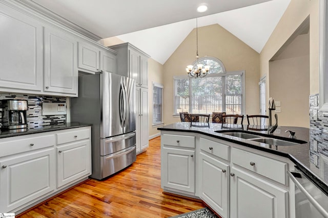 kitchen featuring stainless steel appliances, white cabinetry, a chandelier, and decorative backsplash