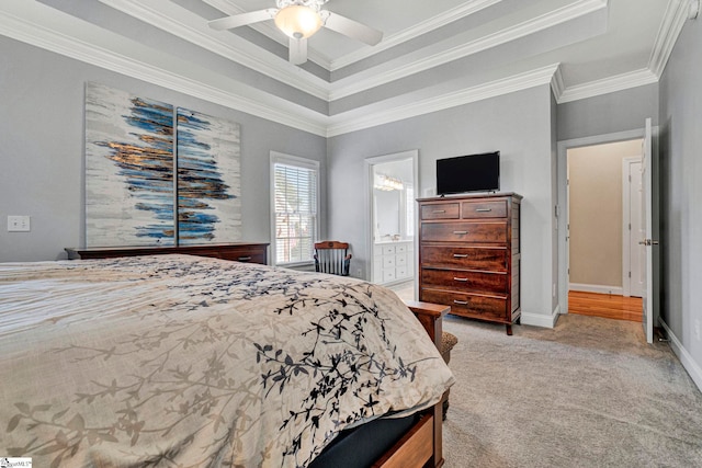 bedroom with ensuite bath, a raised ceiling, ceiling fan, and crown molding