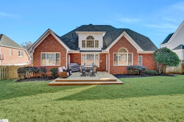 rear view of house with a deck and a yard