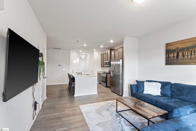 living room featuring sink and light hardwood / wood-style flooring