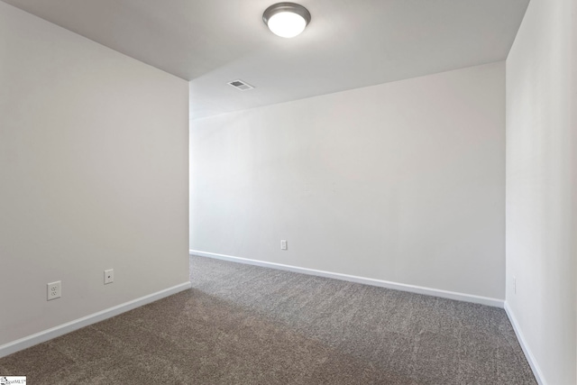 unfurnished room featuring dark carpet