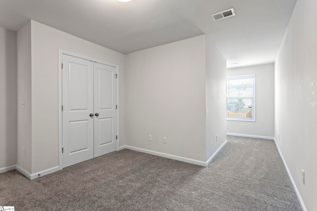 unfurnished bedroom featuring carpet floors and a closet