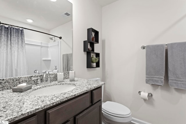 bathroom with toilet, vanity, and curtained shower