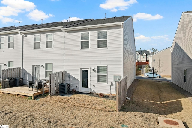 back of property featuring a deck, a yard, and central AC unit