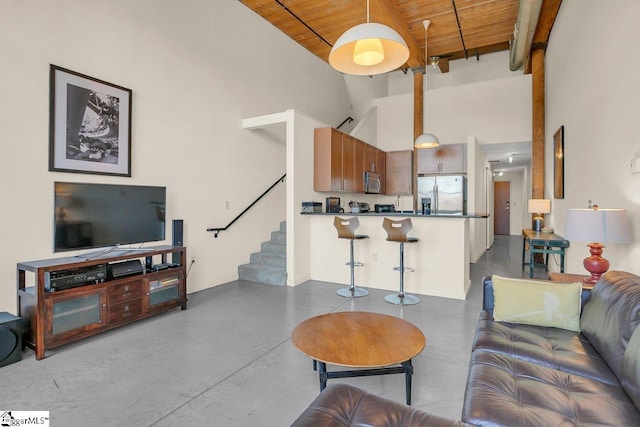 living room featuring wood ceiling, a towering ceiling, and beamed ceiling