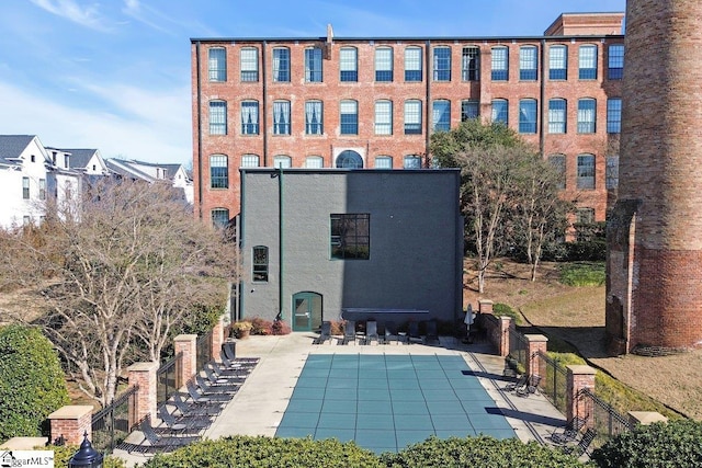 back of property featuring a patio and a community pool