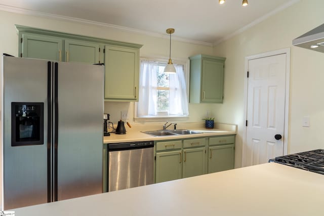 kitchen with hanging light fixtures, green cabinetry, crown molding, appliances with stainless steel finishes, and sink