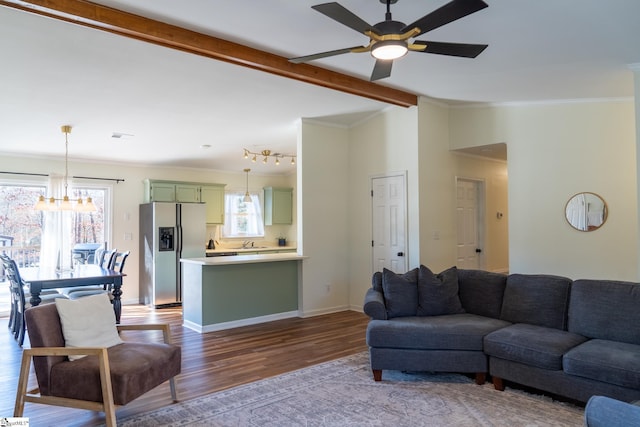 living room featuring ceiling fan with notable chandelier, lofted ceiling with beams, hardwood / wood-style floors, and ornamental molding