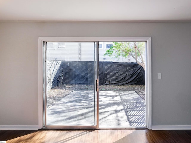 doorway featuring hardwood / wood-style flooring and crown molding