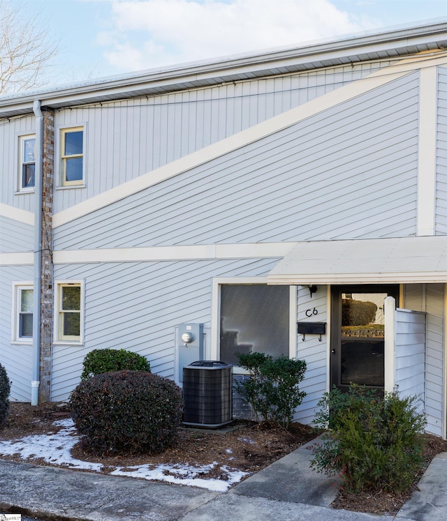 snow covered property with central air condition unit