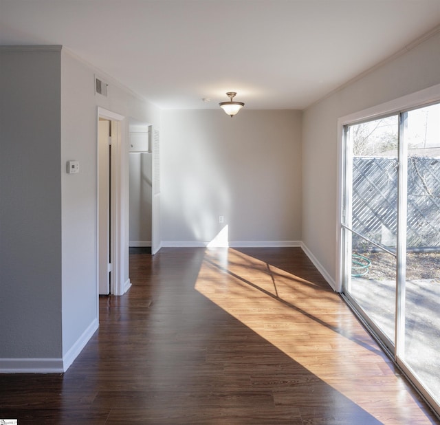 unfurnished room featuring dark wood-type flooring and crown molding