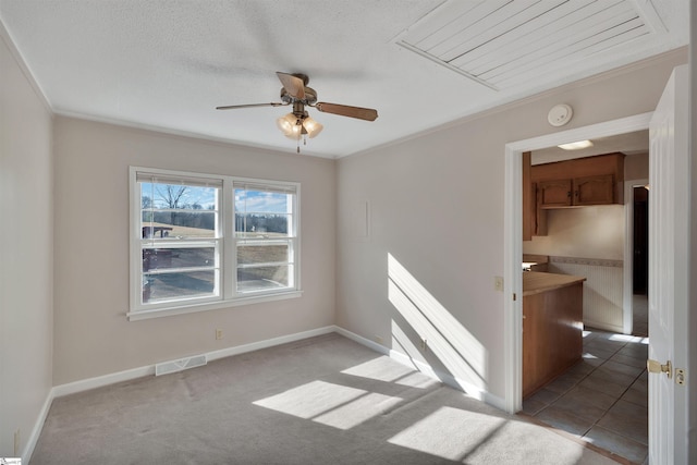 spare room featuring ceiling fan, ornamental molding, and light colored carpet