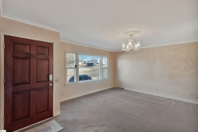 carpeted entryway featuring ornamental molding, a textured ceiling, and a chandelier