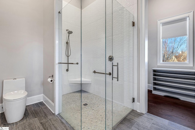 bathroom featuring toilet, an enclosed shower, and hardwood / wood-style flooring