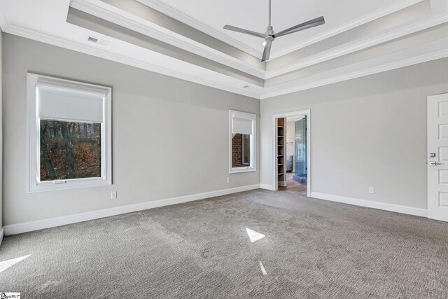 empty room featuring ceiling fan, crown molding, a raised ceiling, and carpet