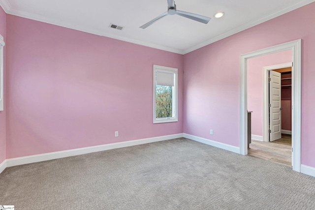 unfurnished room featuring ceiling fan, light colored carpet, and crown molding