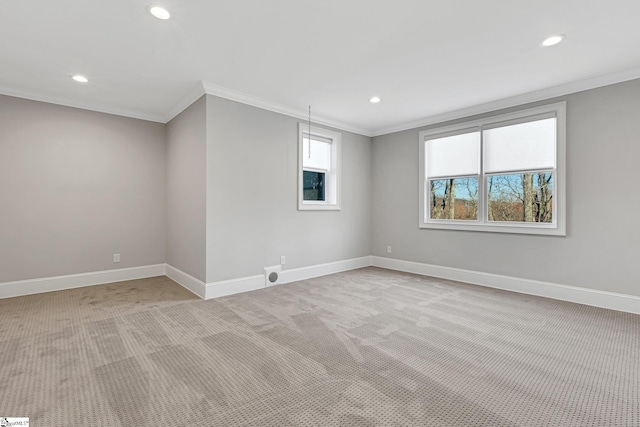 spare room with light colored carpet, a wealth of natural light, and crown molding