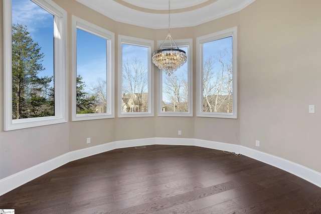 spare room with ornamental molding, an inviting chandelier, and wood-type flooring