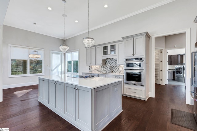 kitchen with backsplash, dark hardwood / wood-style flooring, pendant lighting, gray cabinetry, and appliances with stainless steel finishes