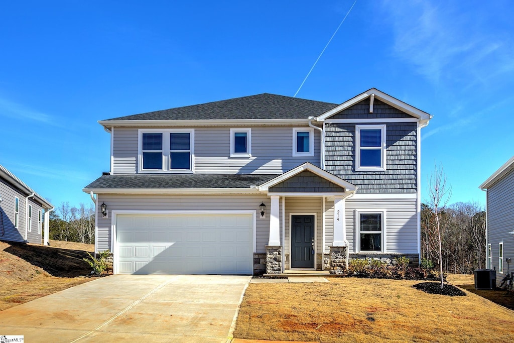 view of front of home featuring central air condition unit and a garage