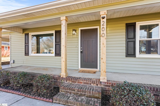 view of exterior entry featuring covered porch