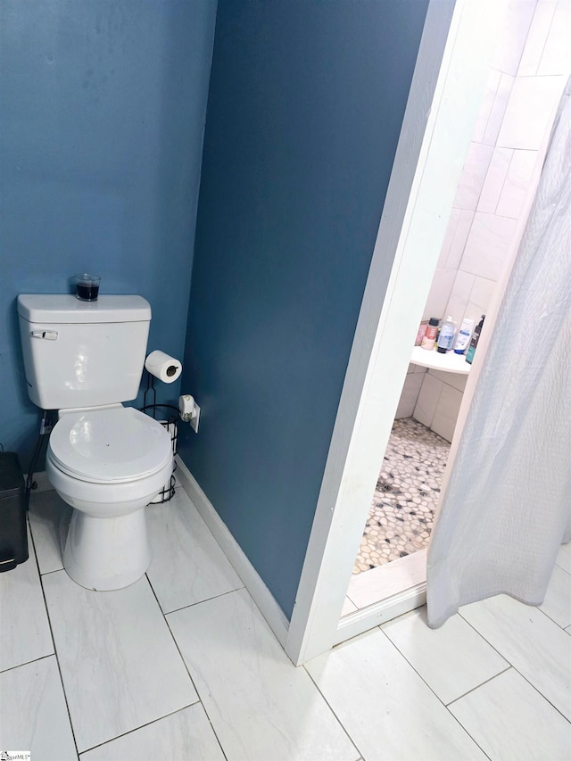 bathroom with walk in shower, tile patterned flooring, and toilet