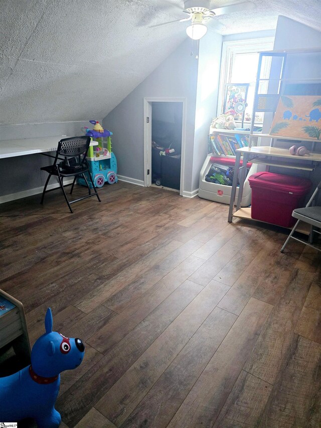 bonus room with a textured ceiling, ceiling fan, vaulted ceiling, and dark hardwood / wood-style floors