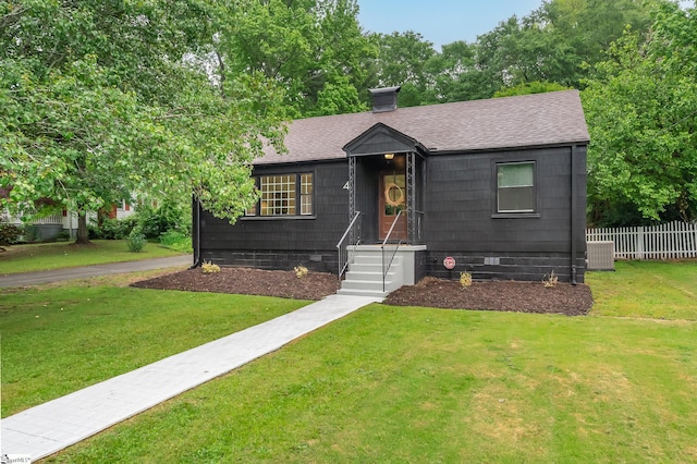 view of front of house with central air condition unit and a front yard