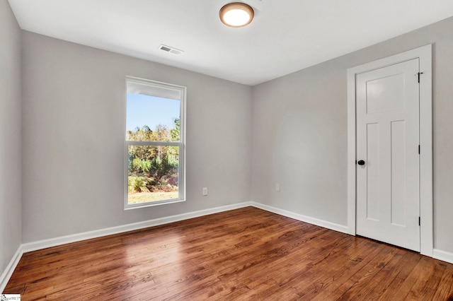 unfurnished room with hardwood / wood-style flooring