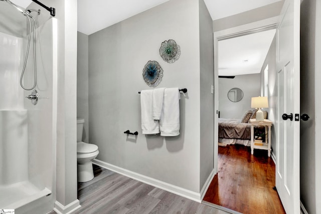 bathroom with toilet, hardwood / wood-style flooring, and walk in shower