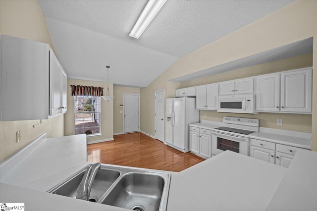 kitchen featuring white cabinetry, a textured ceiling, vaulted ceiling, white appliances, and pendant lighting