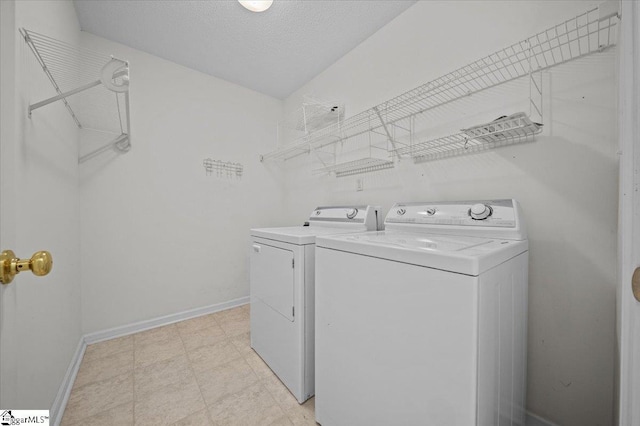 washroom featuring separate washer and dryer and a textured ceiling