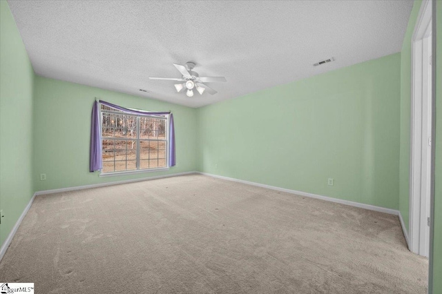 carpeted spare room with a textured ceiling and ceiling fan