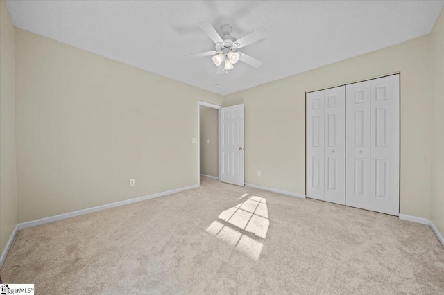 unfurnished bedroom with light carpet, a closet, and ceiling fan