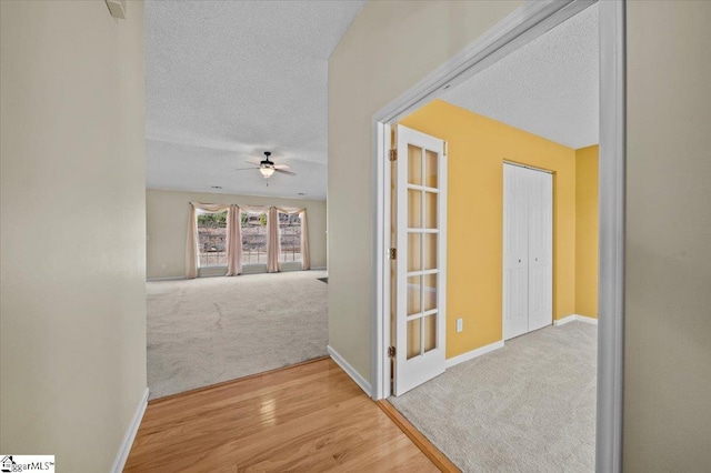 corridor featuring a textured ceiling and carpet