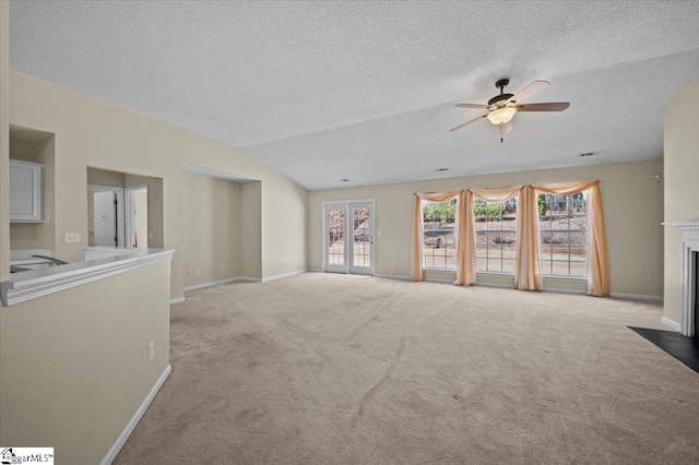 unfurnished living room featuring ceiling fan, vaulted ceiling, light carpet, and a textured ceiling