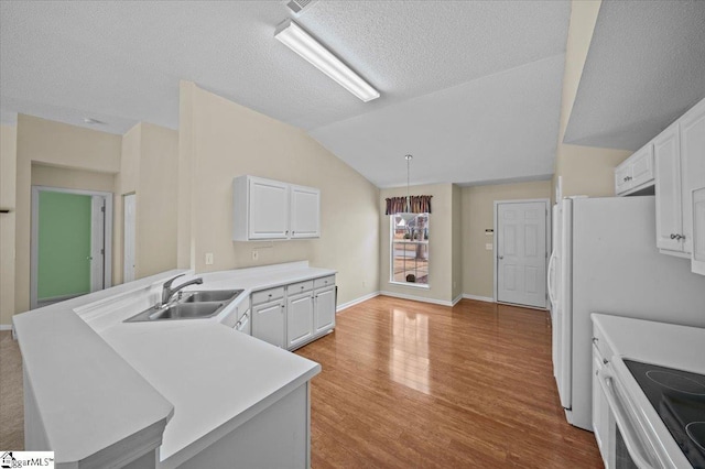 kitchen with white cabinets, decorative light fixtures, lofted ceiling, and kitchen peninsula