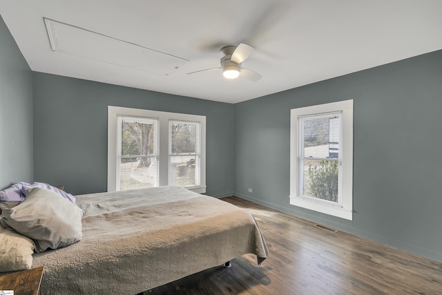 bedroom with multiple windows, ceiling fan, and hardwood / wood-style flooring