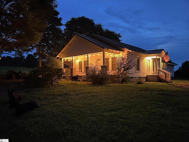 property exterior at dusk with a yard