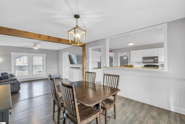 dining room with ceiling fan with notable chandelier, dark hardwood / wood-style flooring, and beamed ceiling