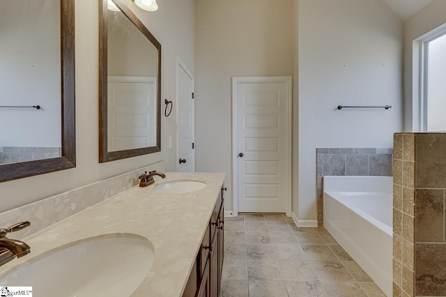 bathroom featuring lofted ceiling, a tub, and vanity