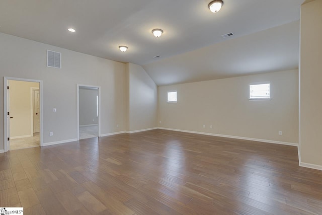 spare room featuring lofted ceiling and wood-type flooring