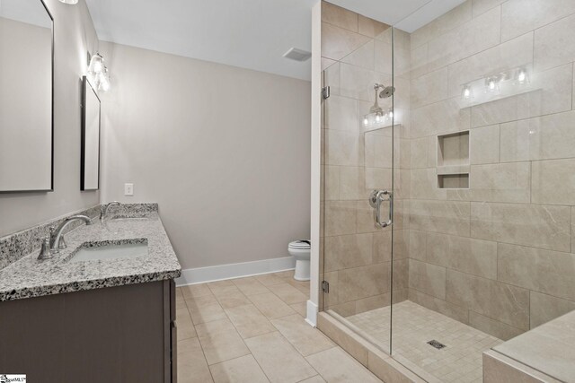 bathroom with toilet, a shower with door, vanity, and tile patterned floors