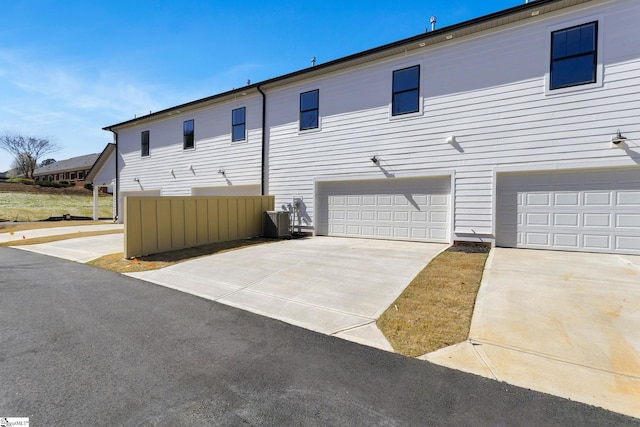 view of property exterior featuring a garage and cooling unit